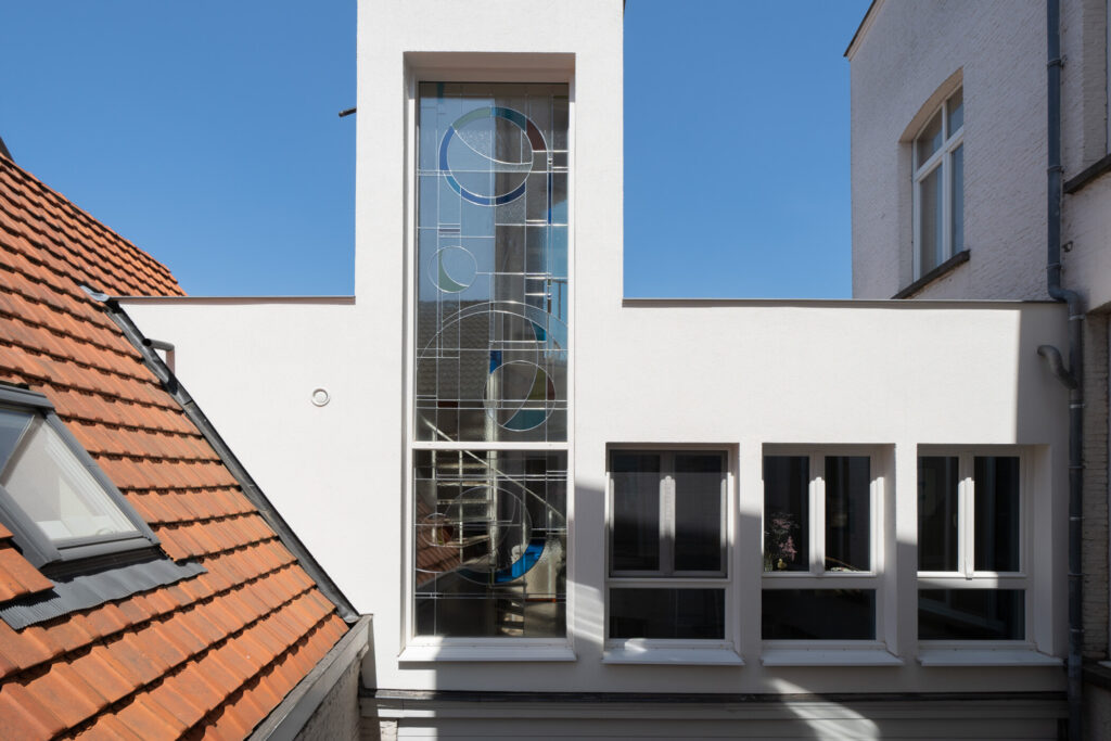 Groots glas-in-lood raam verbindt historie en moderniteit in traditioneel Antwerps rijhuis